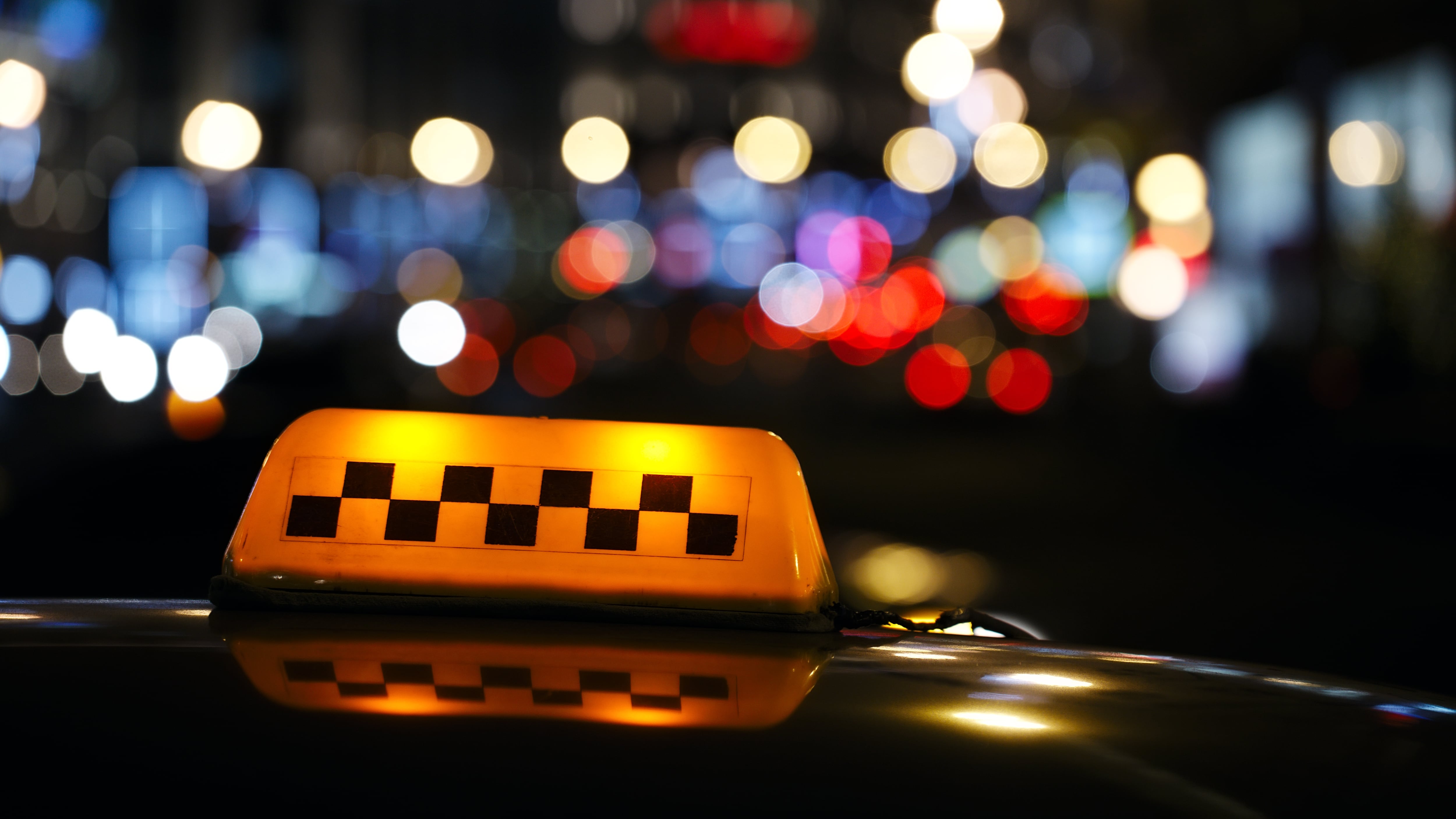 Letrero iluminado de taxi en una calle de la ciudad.