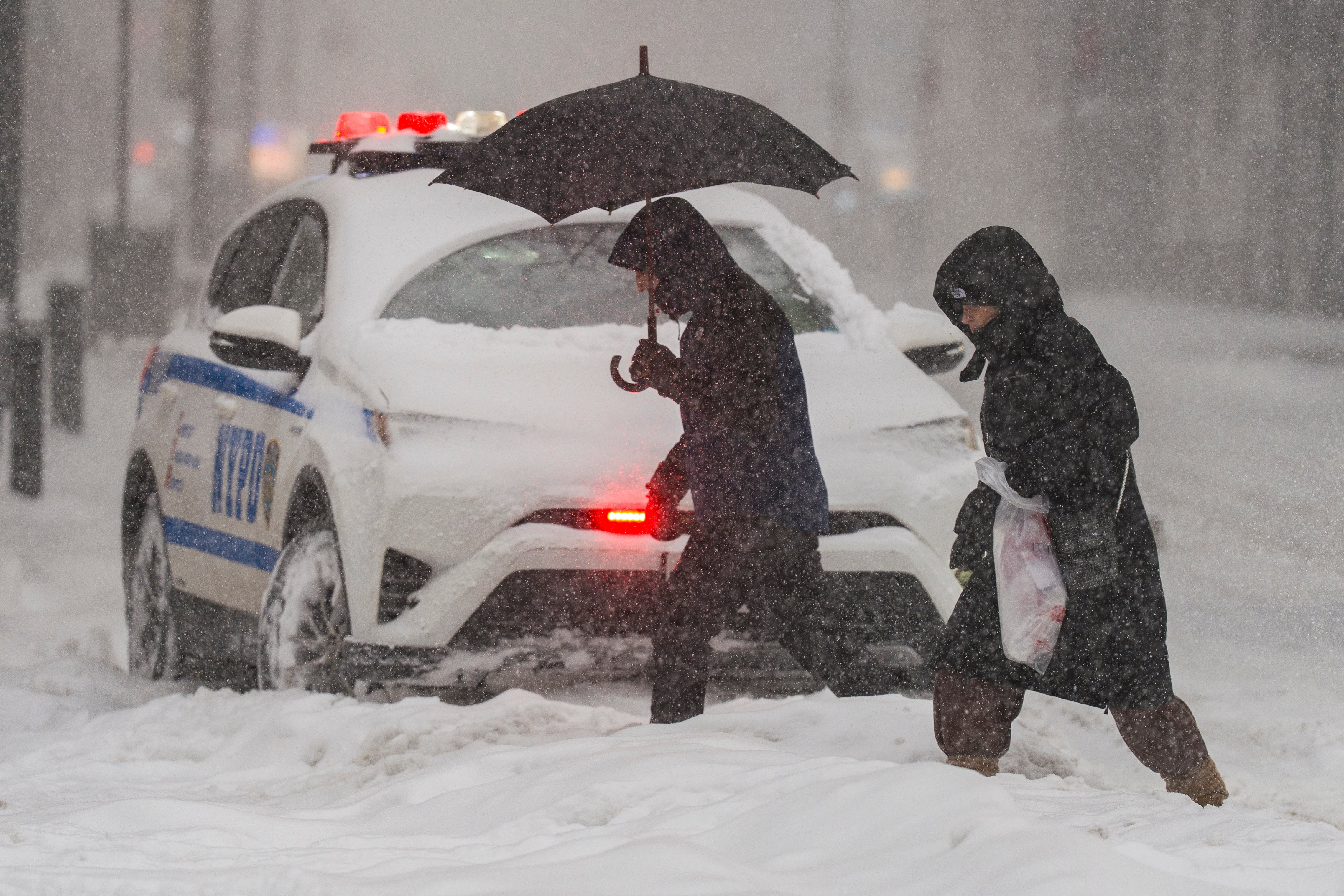 AME8351. MANHATTAN (ESTADOS UNIDOS), 25/01/2026.- Personas caminan durante una nevada este domingo, en Manhattan (Estados Unidos). La gran tormenta de hielo y nieve que ha afectado a dos tercios de la geografía estadounidense ha dejado este domingo a más de 700.000 hogares, principalmente en estados del sur, sin suministro eléctrico. EFE/ Ángel Colmenares