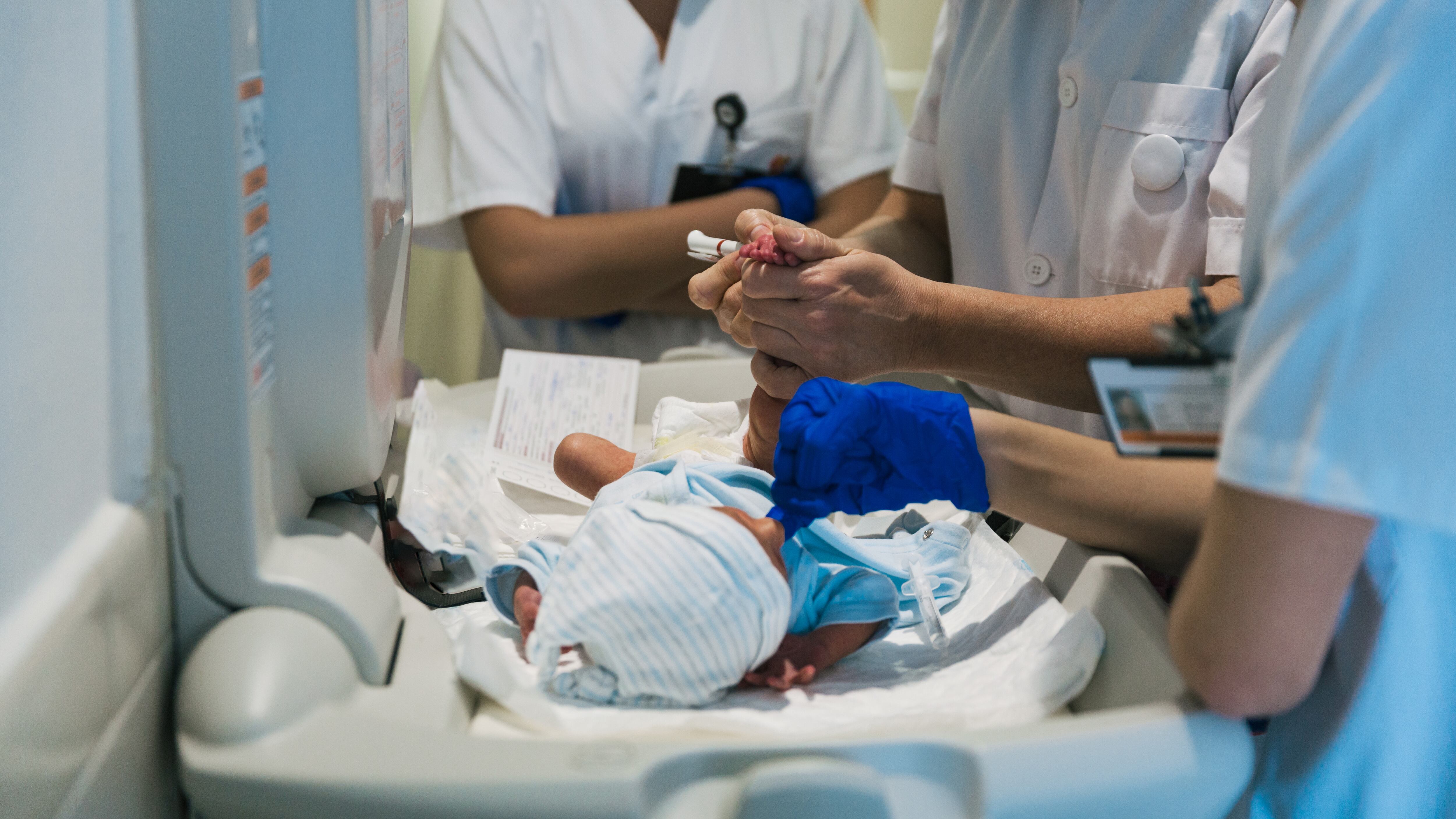 Equipo médico examinan al bebé recién nacido en el hospital