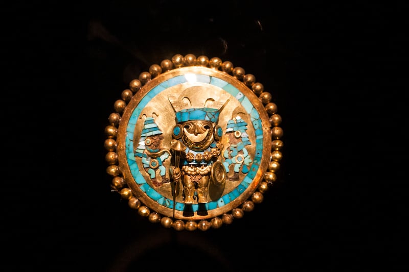 Orejera de oro y turquesa con representación del guerrero hallada en la tumba del Señor de Sipán. Museo Tumbas Reales de Sipán.