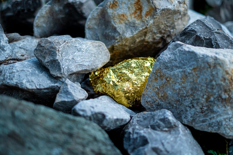 Gold nugget and grey granite stone background