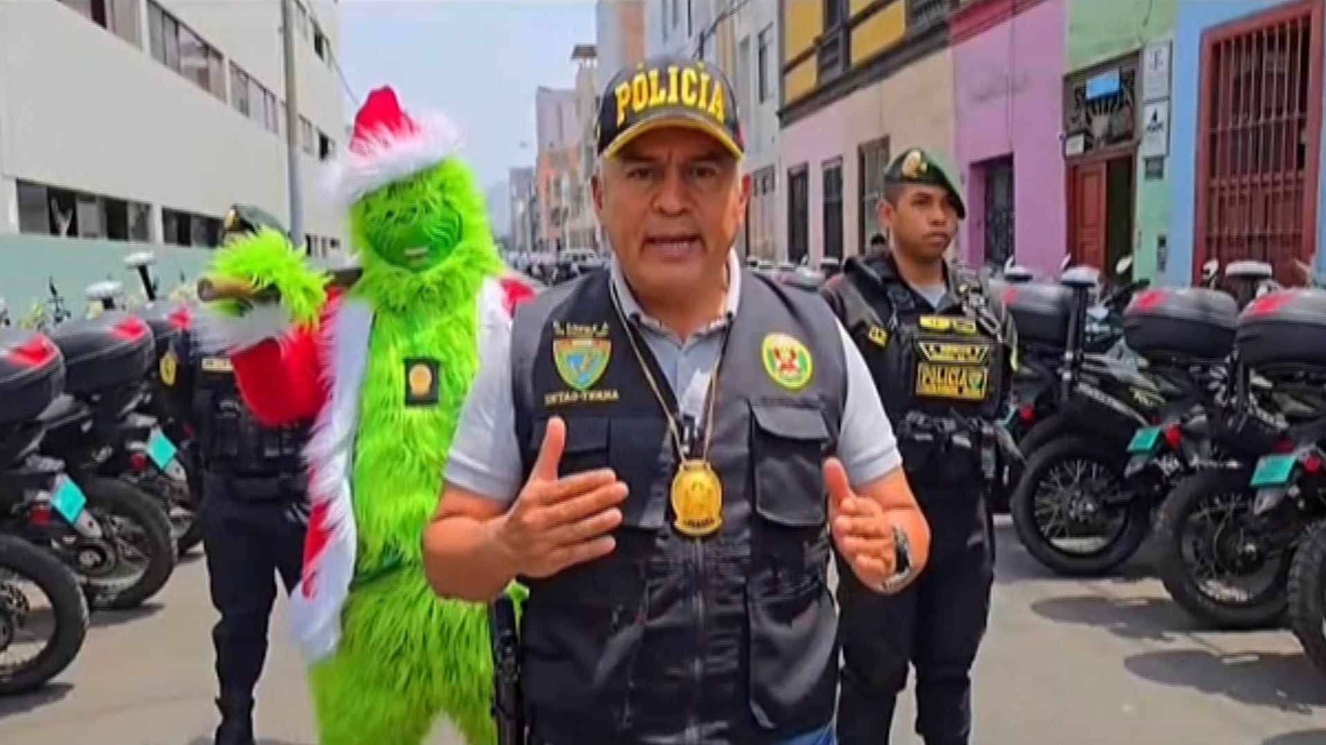 Captura de pantalla de un video de la Policía Nacional del Perú (PNP) de un policía (i) disfrazado como el personaje navideño del 'Grinch'. Un agente del PNP se disfrazó como el personaje navideño del 'Grinch' para sorprender "con las manos en la masa" a un clan de comercializadores de drogas en un distrito costero del sur de Lima, informó este lunes el Ministerio del Interior.