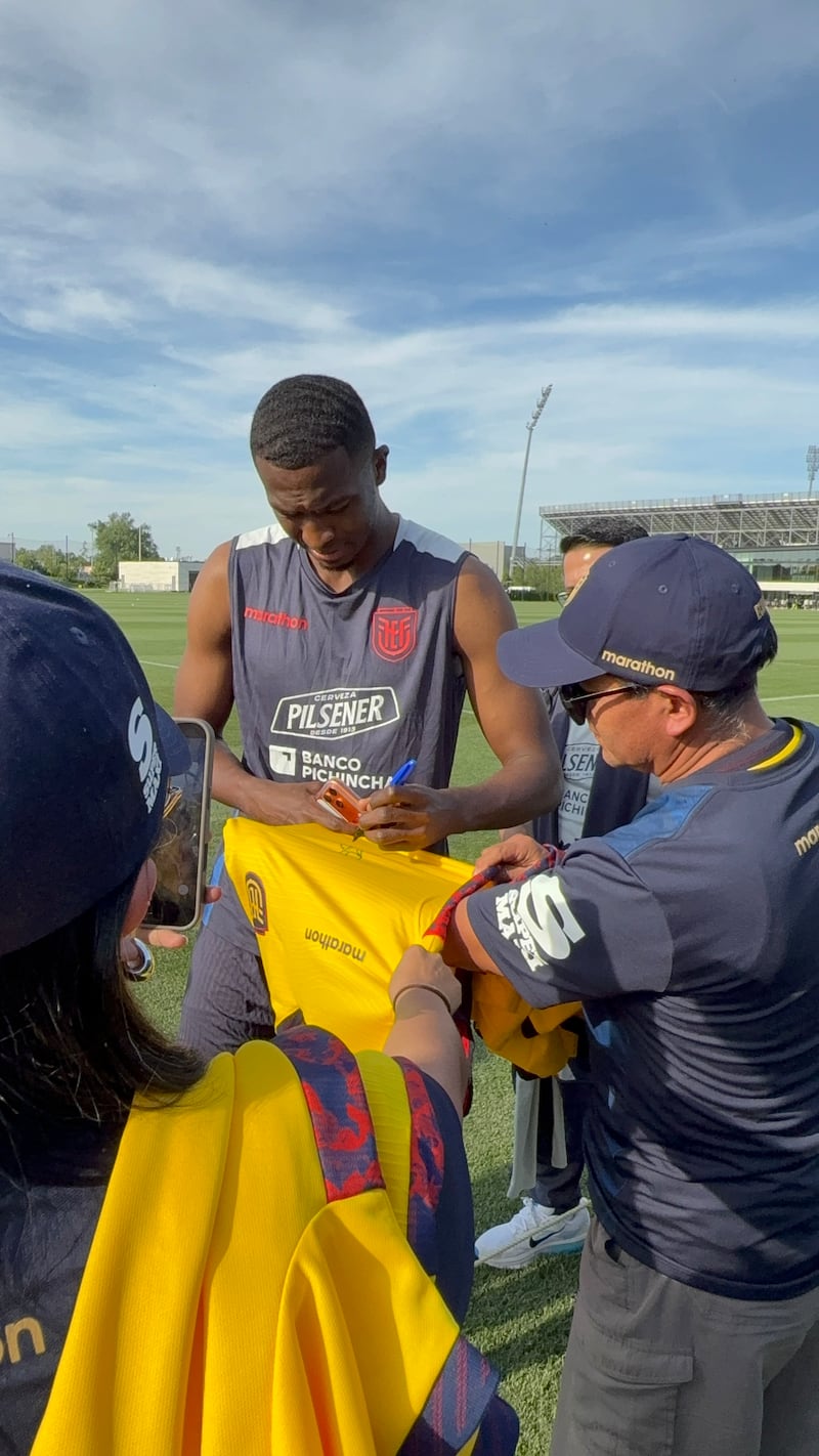 William Pacho firmando las camisetas de los ganadores de Supermaxi y Megamaxi