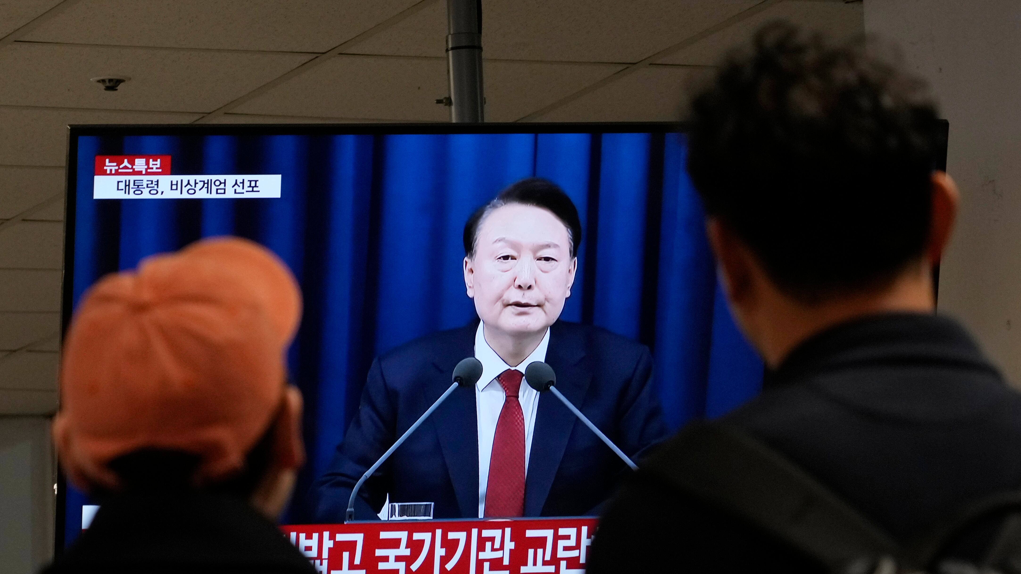 Personas ven un televisor con la imagen del presidente surcoreano Yoon Suk Yeol en una terminal de autobuses en Seúl, Corea del Sur, el martes 3 de diciembre de 2024. (AP Foto/Ahn Young-joon)