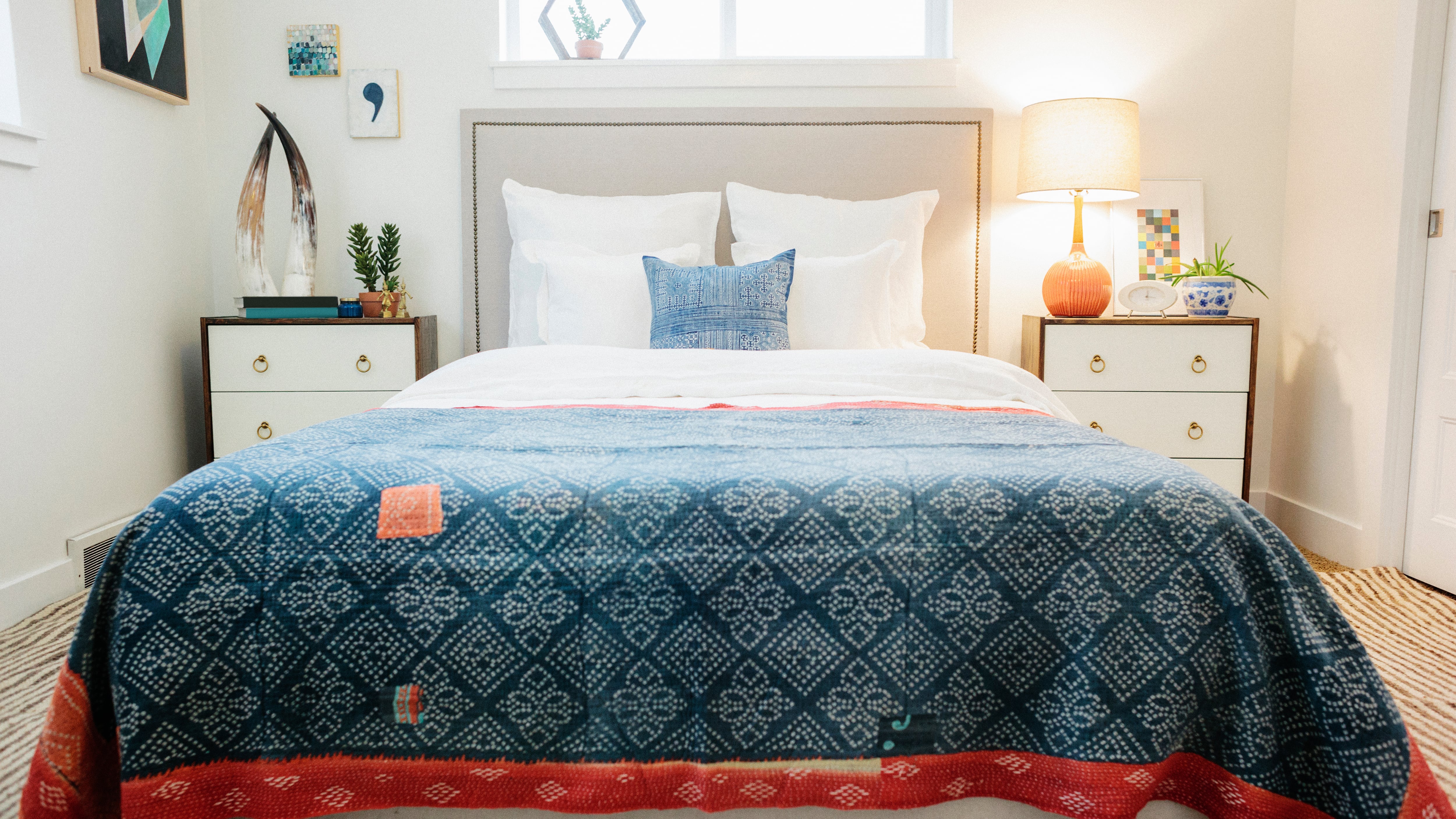 Un dormitorio en un apartamento con una cama doble y una cama de estilo retro con motivos antiguos.