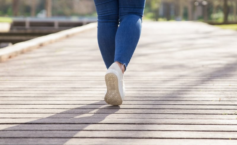 Chica caminando por el sendero en el parque de la ciudad