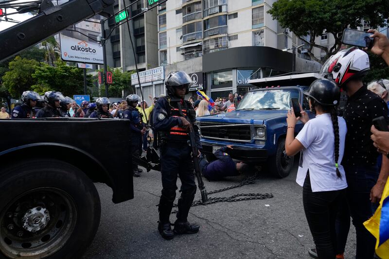 La policía toma posesión del camión desde el cual la líder opositora María Corina Machado se dirigió a sus partidarios en una protesta en Caracas, Venezuela, el jueves 9 de enero de 2025, el día antes de la toma de posesión del presidente Nicolás Maduro para un tercer mandato. (Foto AP/Ariana Cubillos)
