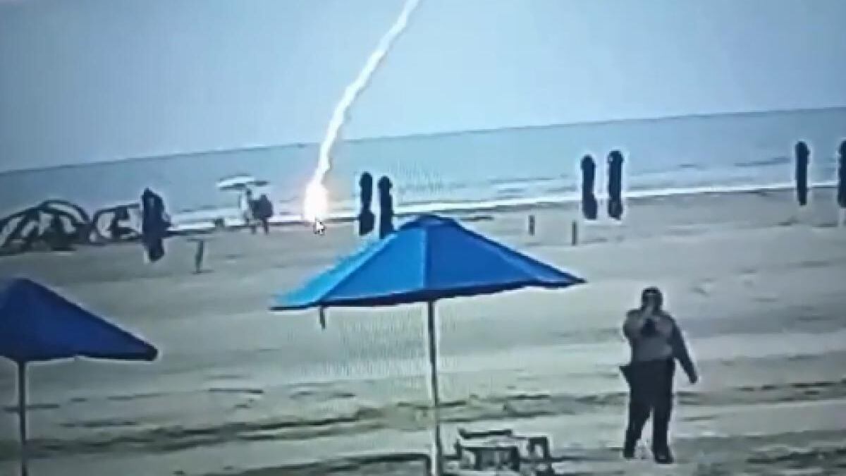 Momento en que un rayo cae sobre una mujer que caminaba en una playa de Cartagena