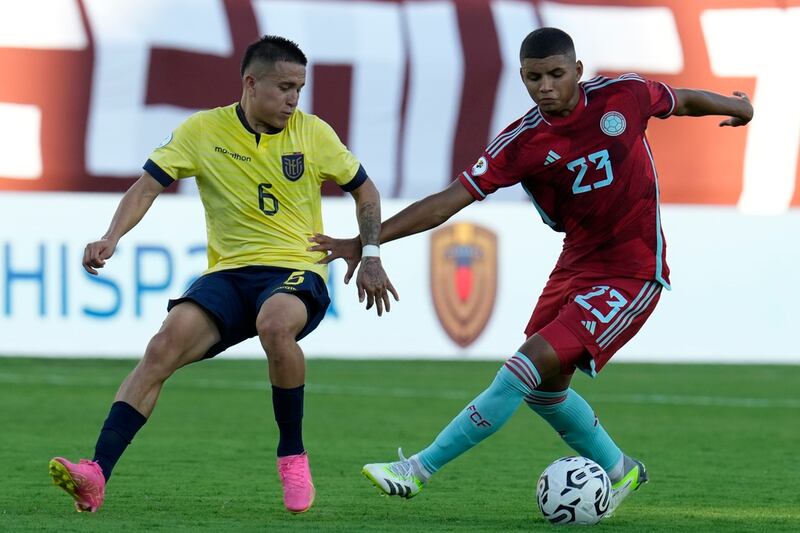 Layan Loor de Ecuador pelea por el balón con el colombiano José Escobar en el encuentro del preolímpico sudamericano sub-23 en el Estadio Brigido Iriarte en Caracas, Venezuela el sábado 20 de enero del 2024. (AP Foto/Ariana Cubillos)