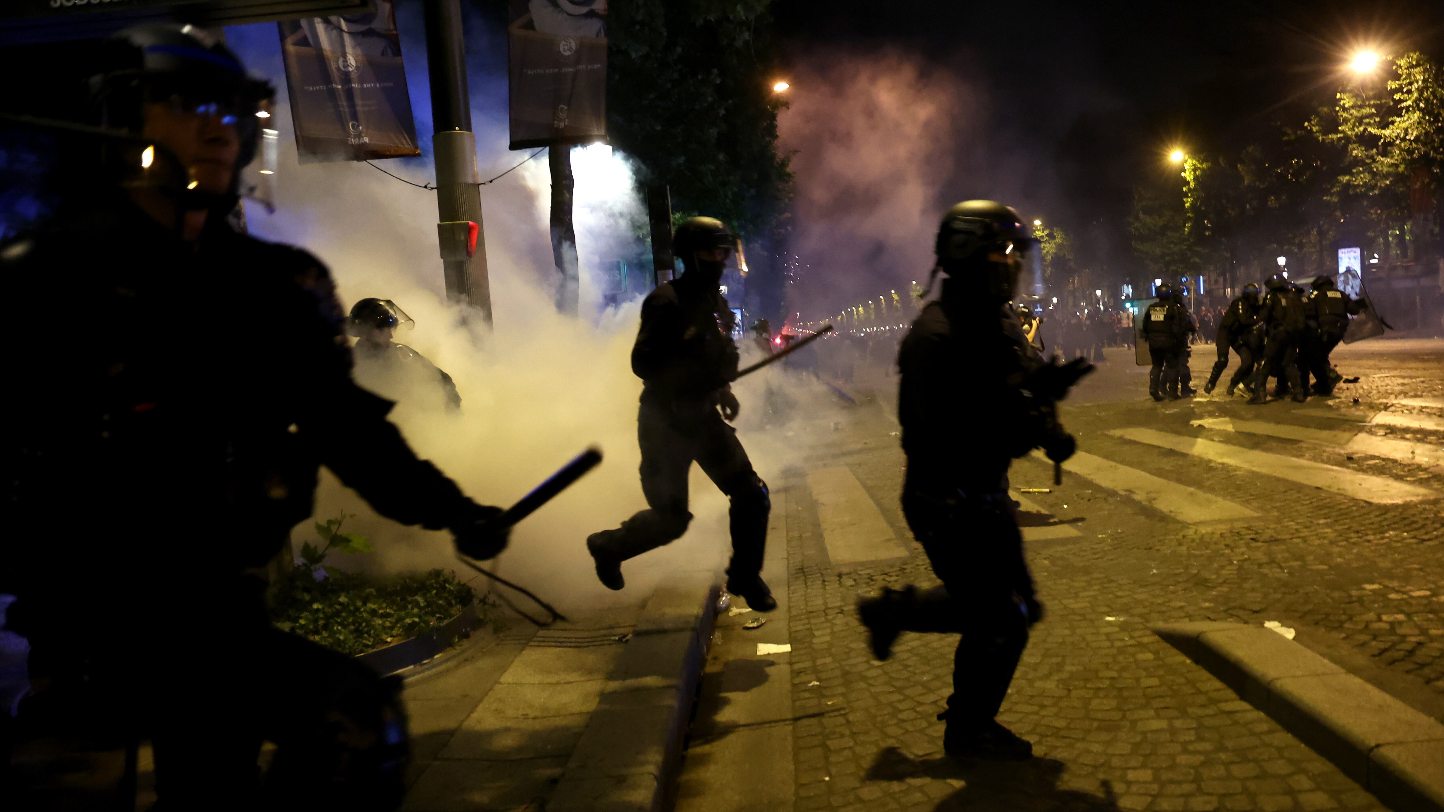 La policía francesa en acción durante los enfrentamientos con los aficionados del PSG que celebran en los Campos Elíseos