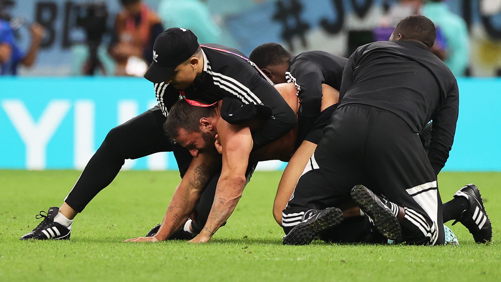 Un invasor del campo es atrapado por seguridad durante el partido de cuartos de final entre Holanda y Argentina