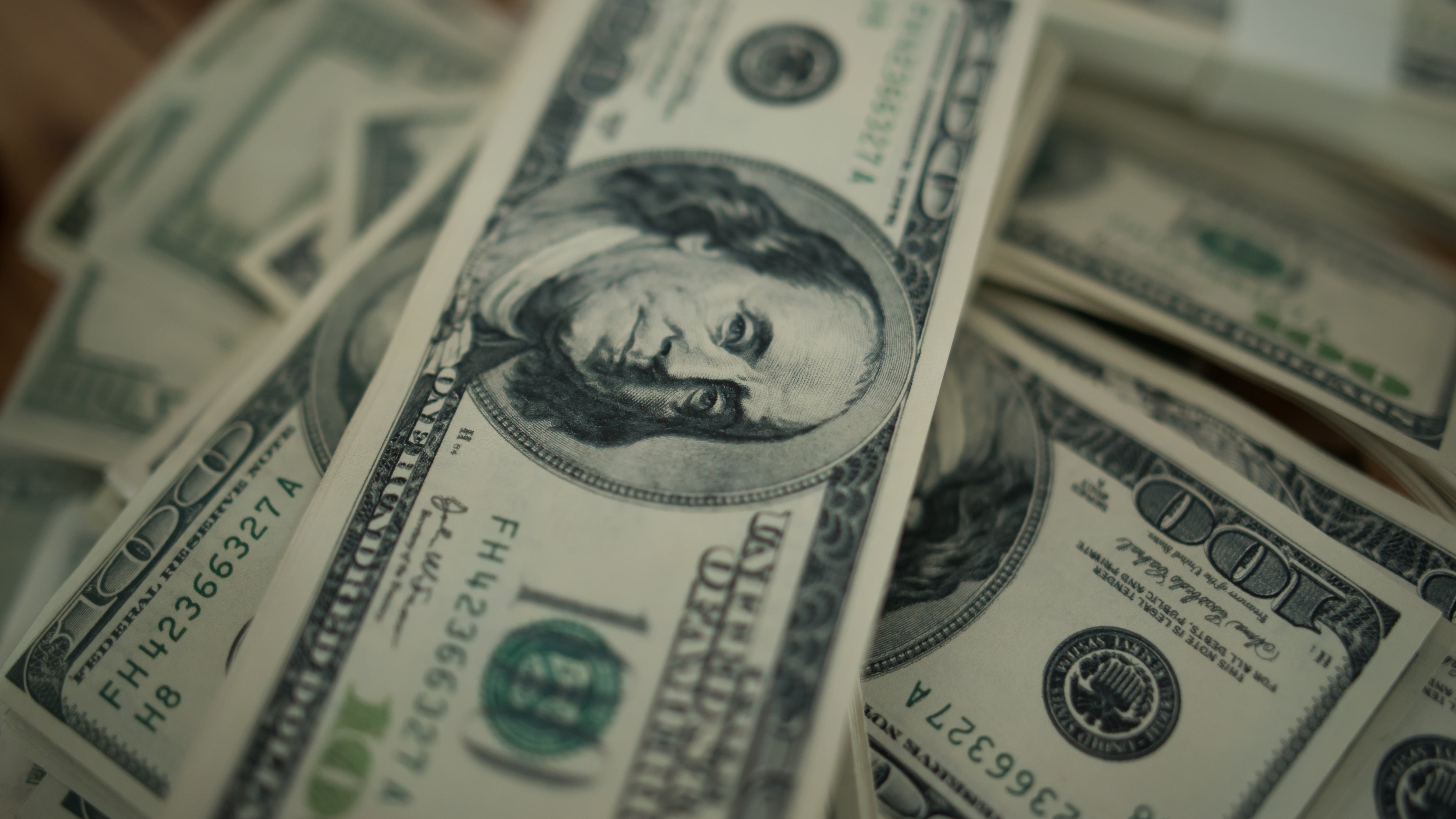 Cien dólares se amontonan como fondo.