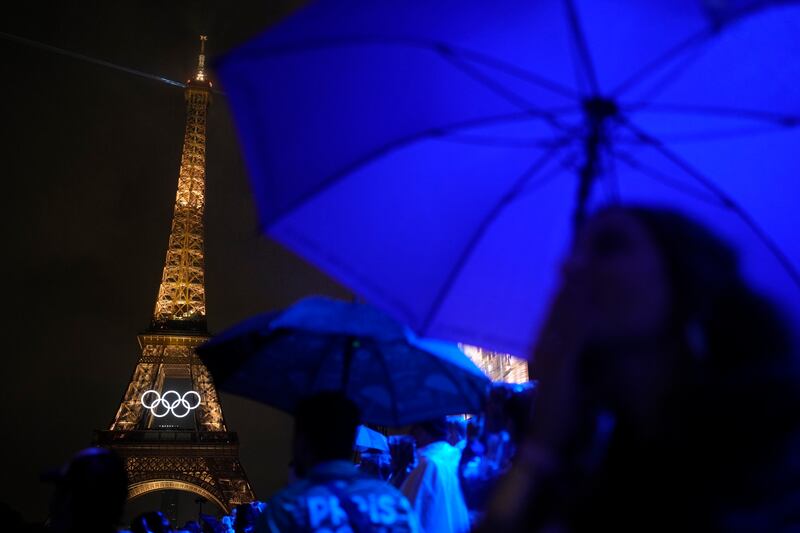 La Torre Eiffel luce iluminada bajo la lluvia el viernes 26 de julio de 2024 durante la inauguración de los Juegos Olímpicos