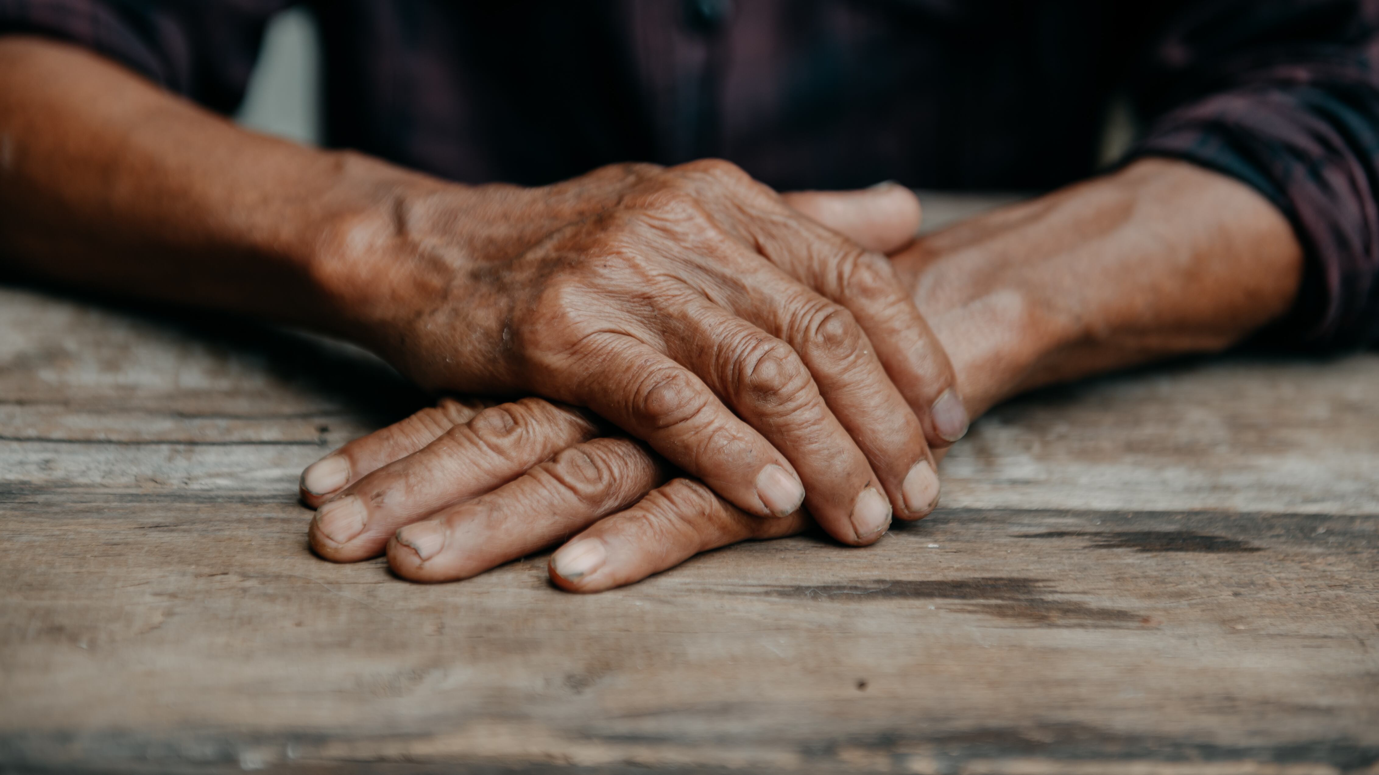 Primer plano de las manos arrugadas de un hombre mayor.