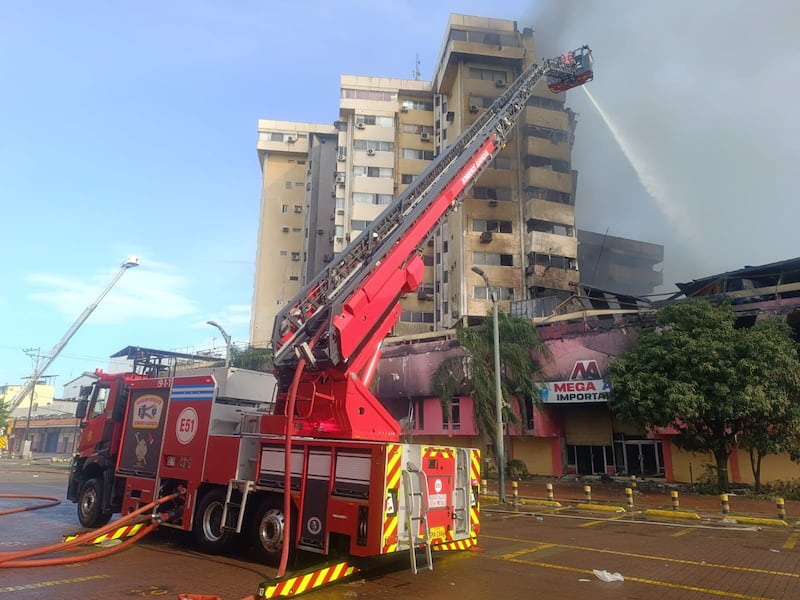 Fotografía del edificio Multicomercio con humo saliendo y zona acordonada por la emergencia.