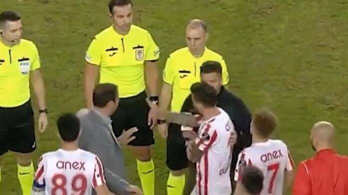El entrenador Nuri Sahin evitando que sus jugadores golpeen al árbitro