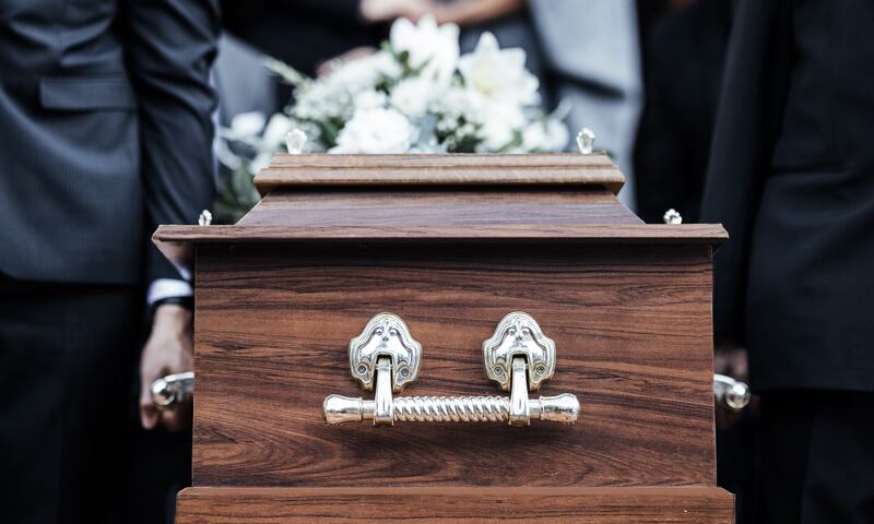 Ataúd, personas y funeral con muerte, dolor y servicio con la familia llevan el ataúd a la tumba al aire libre
