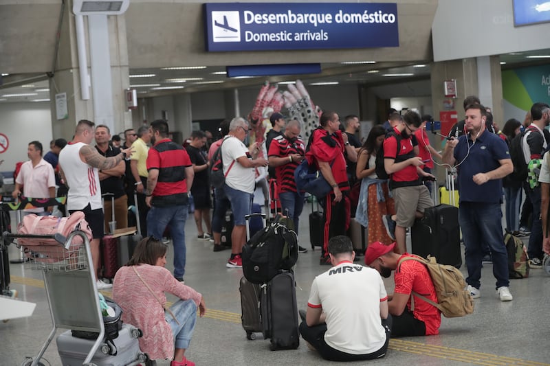 Hinchas de Flamengo esperan sin poder abordar hoy, en el lobby del Aeropuerto Internacional do Galeão, en Río de Janeiro (Brasil).