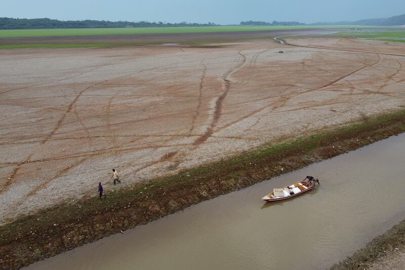 Pescadores empujan un bote en el lago Aleixo en medio de una sequía en Manaus, estado de Amazonas, Brasil, el 24 de septiembre de 2024.