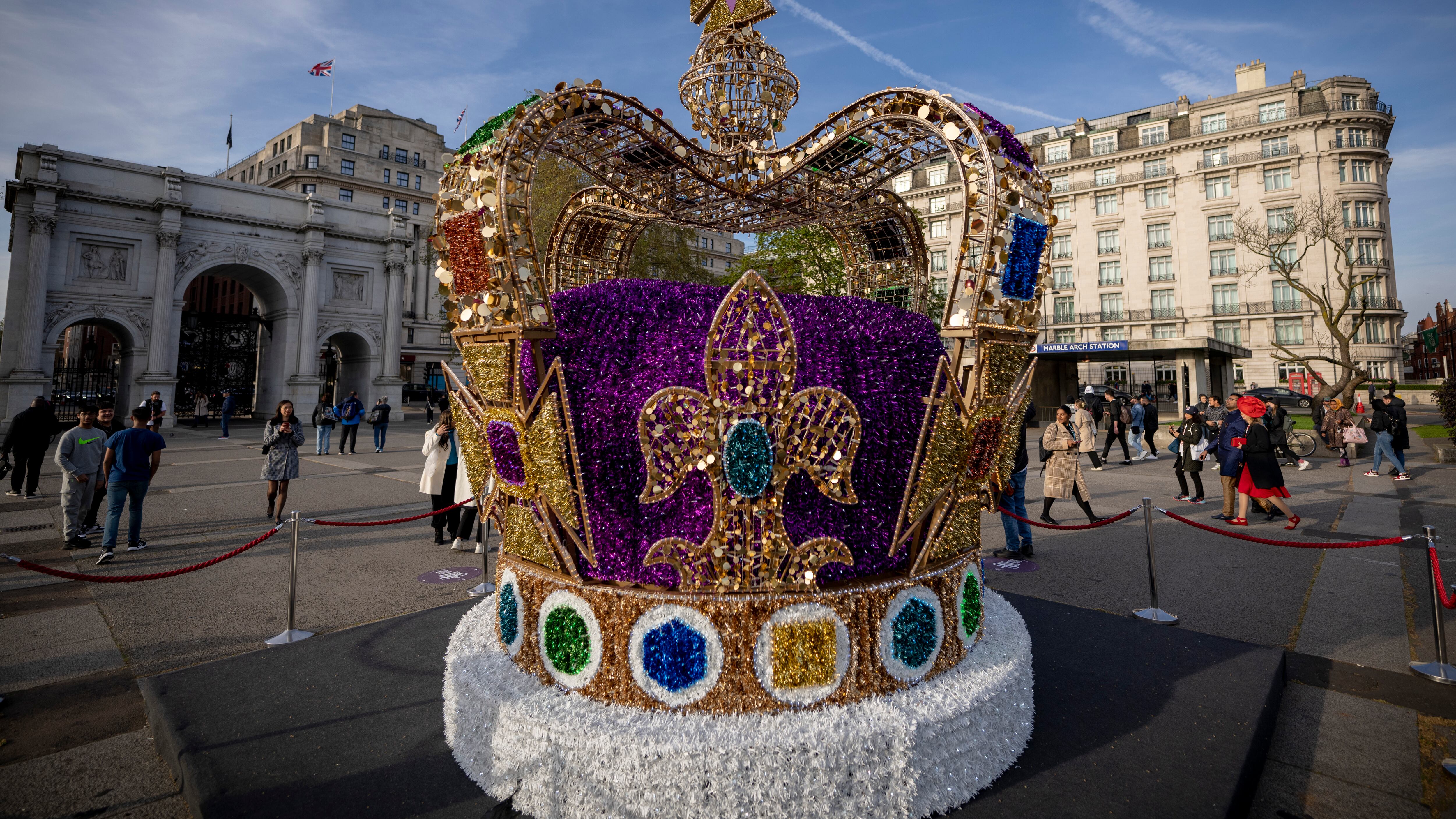 La gente camina frente a una instalación de arte que representa la corona de San Eduardo en el centro de Londres, el miércoles 3 de mayo de 2023. La coronación del rey Carlos III tendrá lugar en la Abadía de Westminster el 6 de mayo. (Foto AP/Vadim Ghirda)
