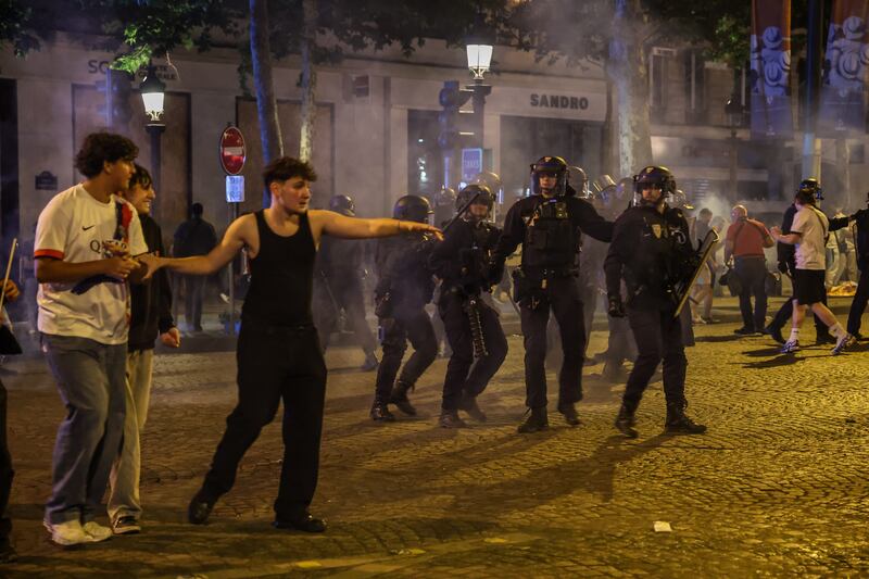 La policía francesa en acción durante los enfrentamientos con los aficionados del PSG que celebran en los Campos Elíseos
