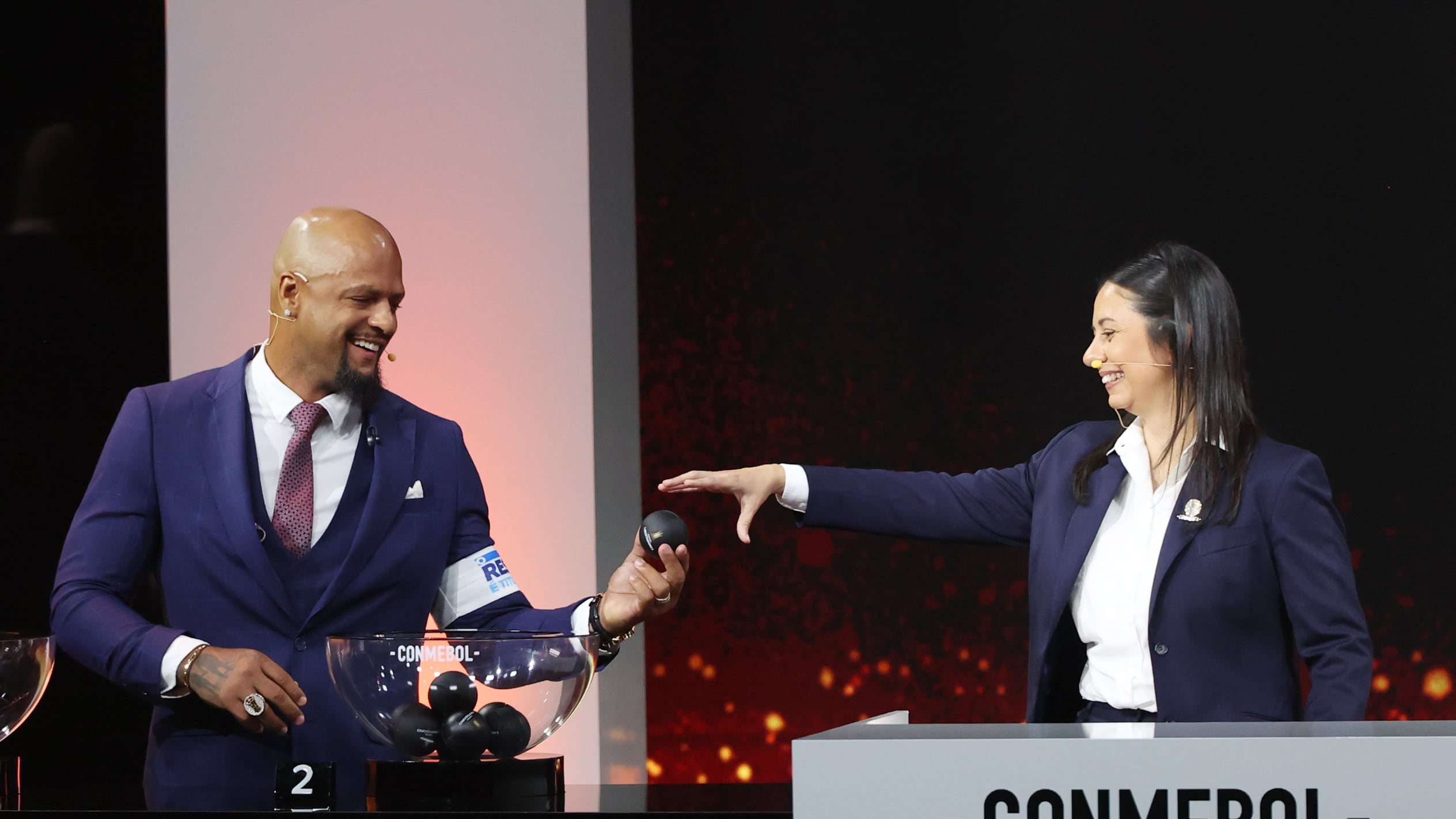 AMDEP2306. LUQUE (PARAGUAY), 19/03/2026.- La gerenta de Competiciones de Conmebol, Luciana Antunes (d), recibe una balota del exjugador brasileño Felipe Melo durante el sorteo de la fase de grupos de la Copa Libertadores este jueves, en Luque (Paraguay). EFE/ Juan Pablo Pino