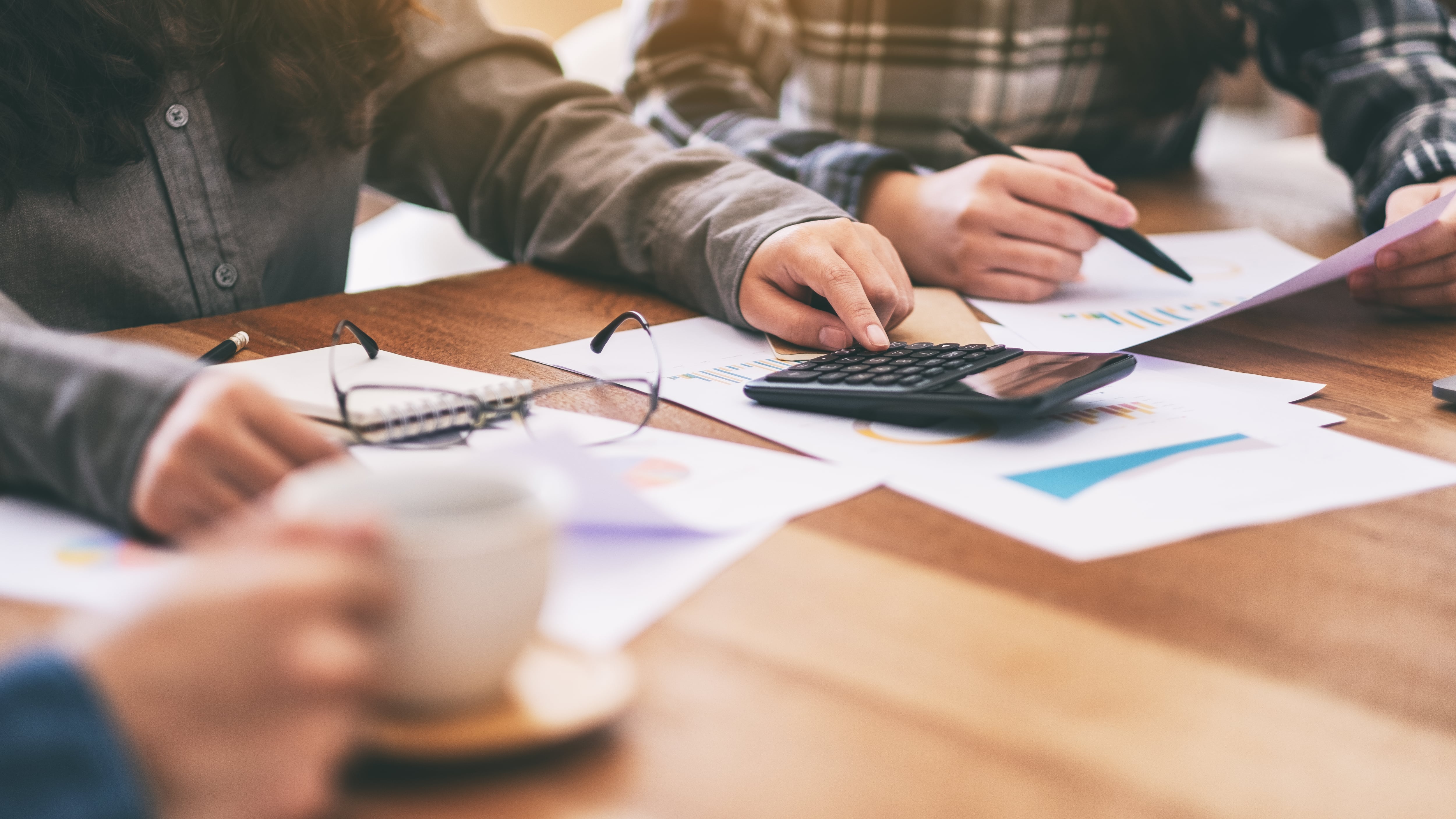 Imagen de primer plano de un hombre de negocios usando una calculadora en una reunión de negocios