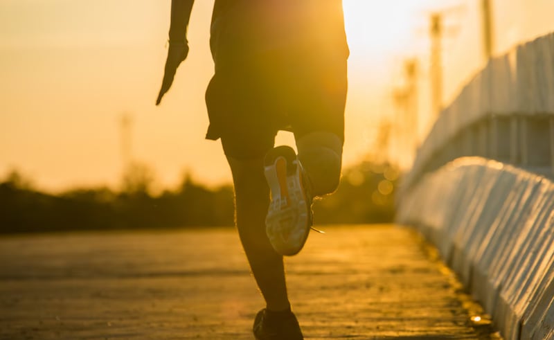 Silueta de un hombre joven fitness correr en atardecer
