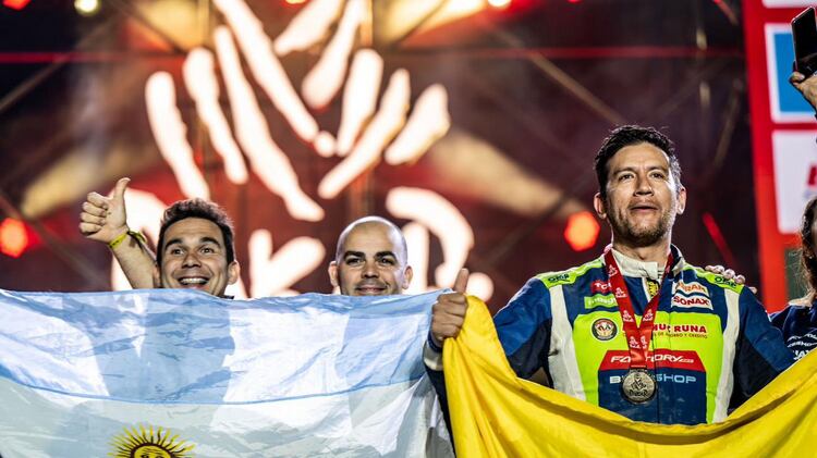 El ecuatoriano Sebastián Guayasamín y su copiloto el argentino Ricardo Torlaschi muestran las banderas de sus naciones orgullosos cuando culminó el Rally Dakar.