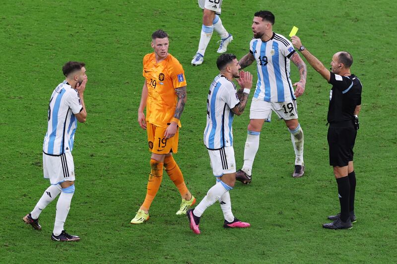 El árbitro Antonio Mateu Lahoz muestra una tarjeta amarilla a German Pezzella (L) de Argentina