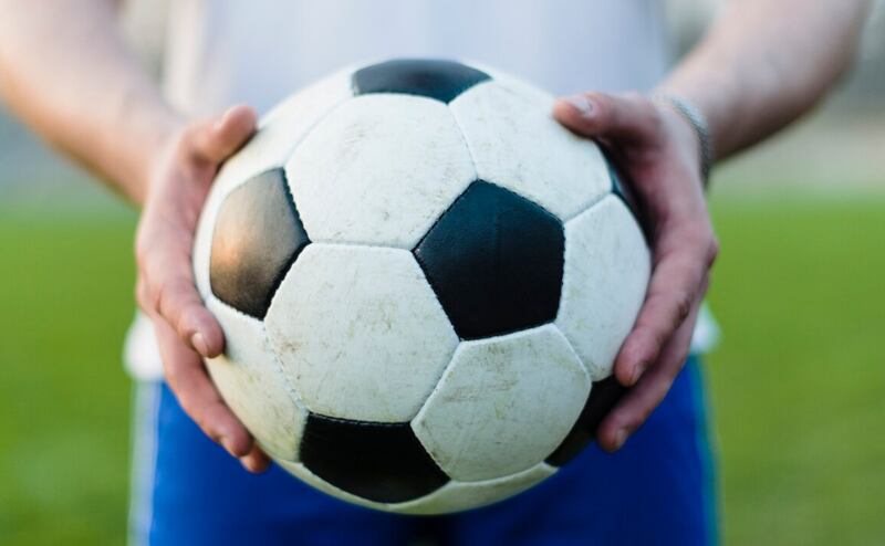 Deportista de cultivos mostrando el balón de fútbol