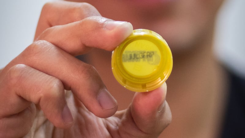 Encuentra el código alfanumérico de 7 dígitos impreso en el interior de la tapa dorada