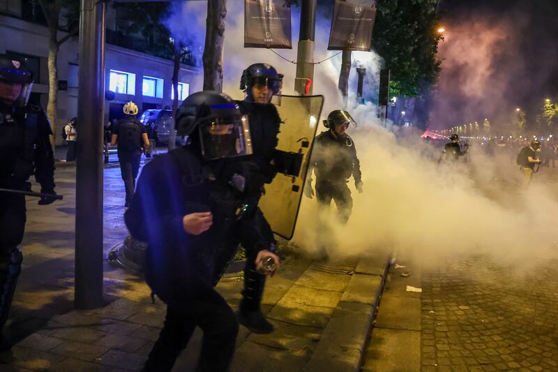 La policía francesa en acción durante los enfrentamientos con los aficionados del PSG que celebran en los Campos Elíseos