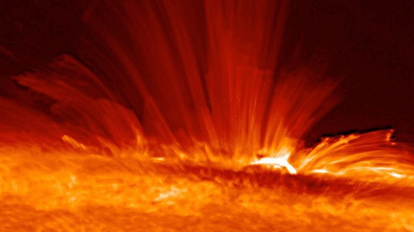 Mancha solar con serpentinas de gas (plasma) súper caliente cargado eléctricamente desde la superficie del Sol