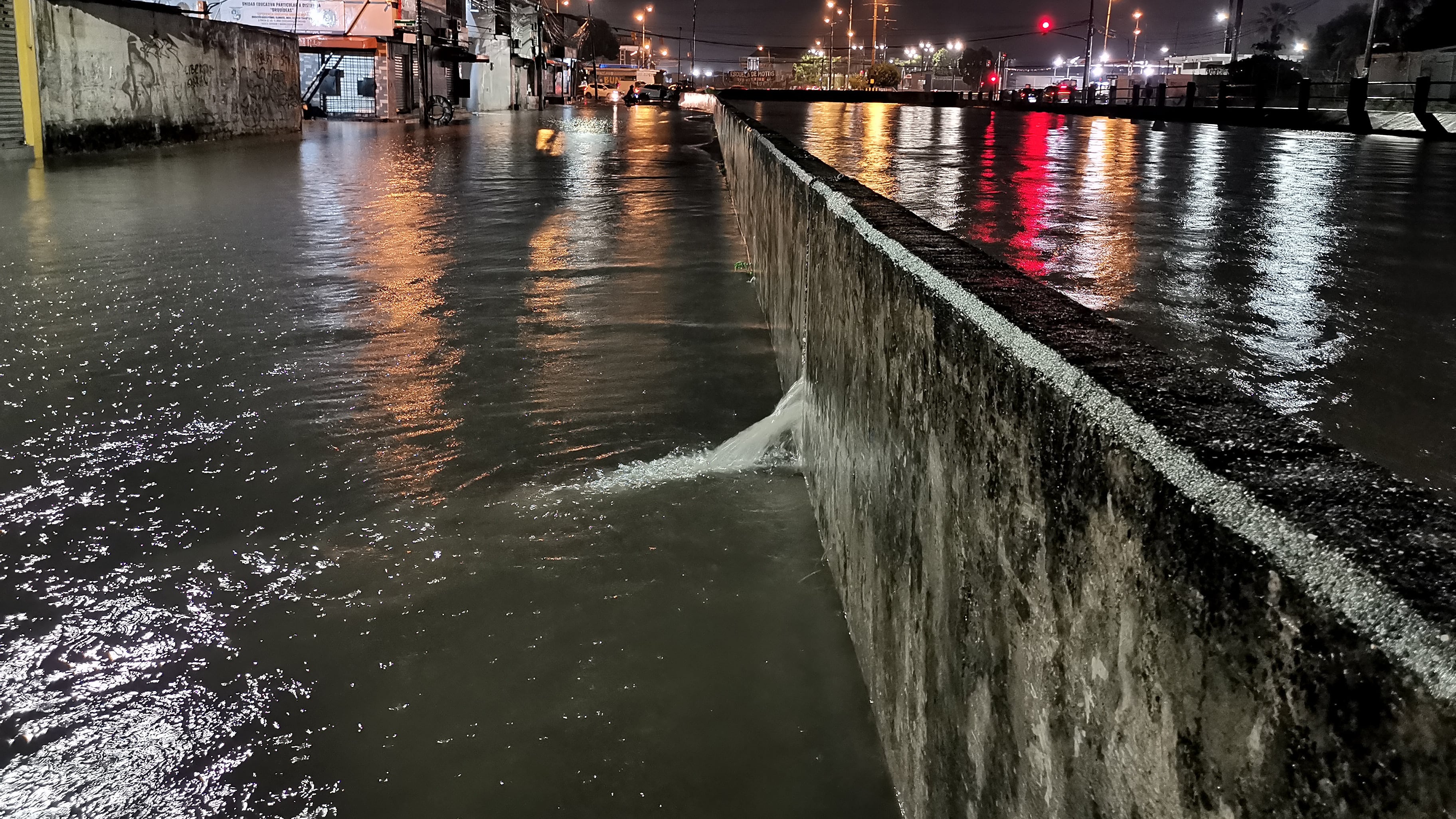Guayaquil, martes 09 de junio del 2026
El canal de aguas lluvias de la ciudadela Las Orquídeas, en el norte de Guayaquil, estuvo a punto de desbordarse por segunda noche consecutiva. La lluvia anegó las calles, mientras moradores piden limpiar el canal y reforzar el muro de contención que registra filtraciones y peligro de colapso.
Fotos: API