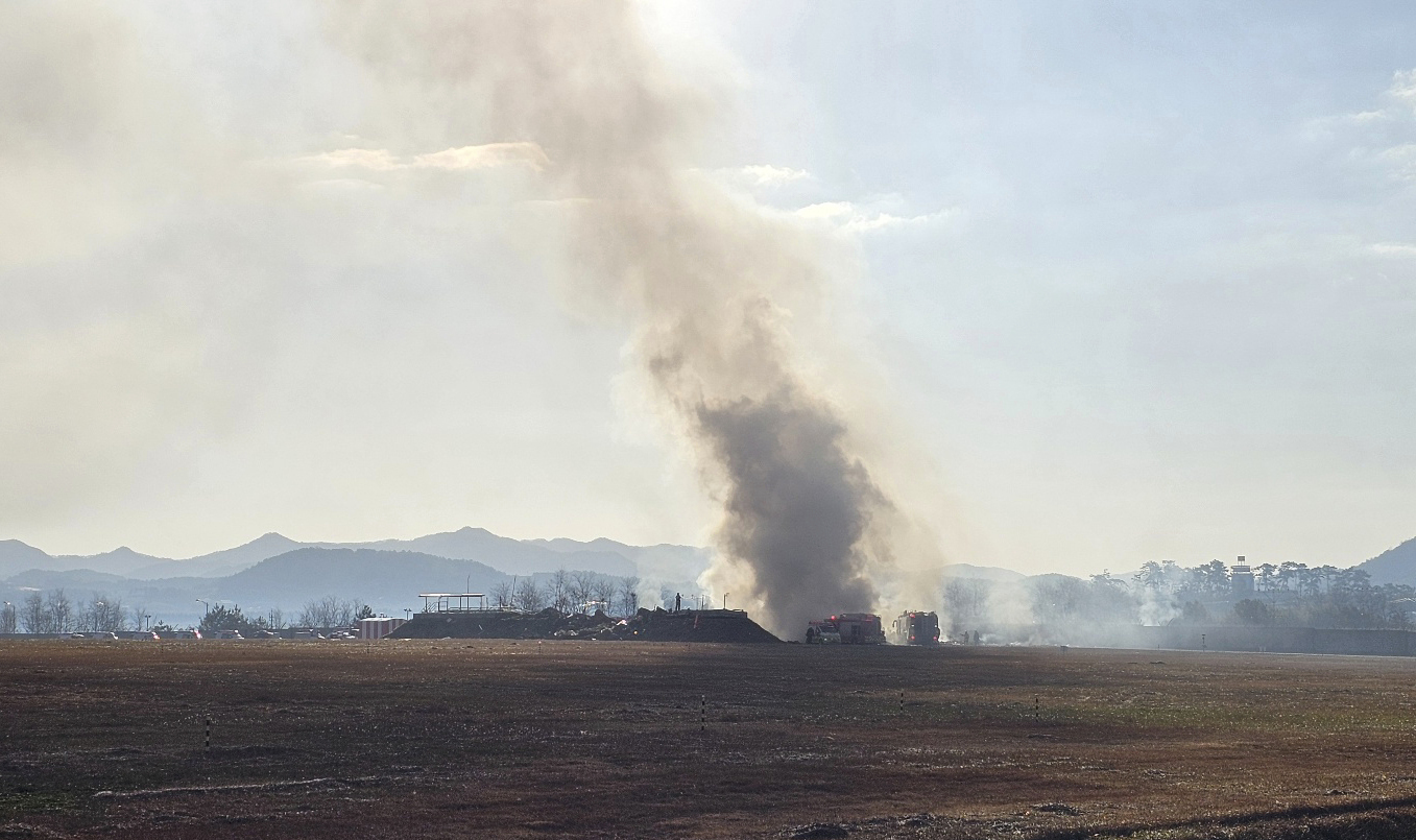 Los bomberos trabajan para extinguir un incendio en la pista de aterrizaje del Aeropuerto Internacional de Muan, el domingo 29 de diciembre de 2024, en Corea del Sur. (Maeng Dae-hwan/Newsis vía AP)